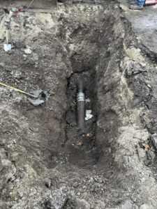A trench dug for utility pipe repair or installation, showing excavation work by Horhut Inc. in Pittsburgh, PA.
