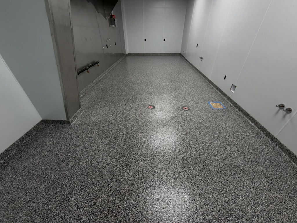 A utility room or corridor with a durable grey speckled epoxy floor coating installed by 812 Concrete Coatings in Evansville, IN.