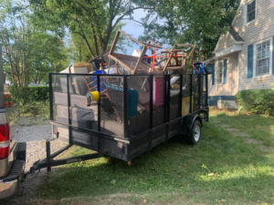 A utility trailer loaded with various household junk items for removal by Fargo's Junk Removal in Nashville, TN.