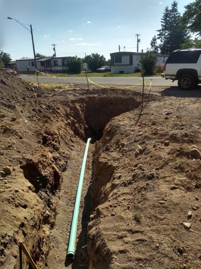 A trench dug for utility pipe installation in a residential area, completed by Aspen Excavation in Spokane, WA.