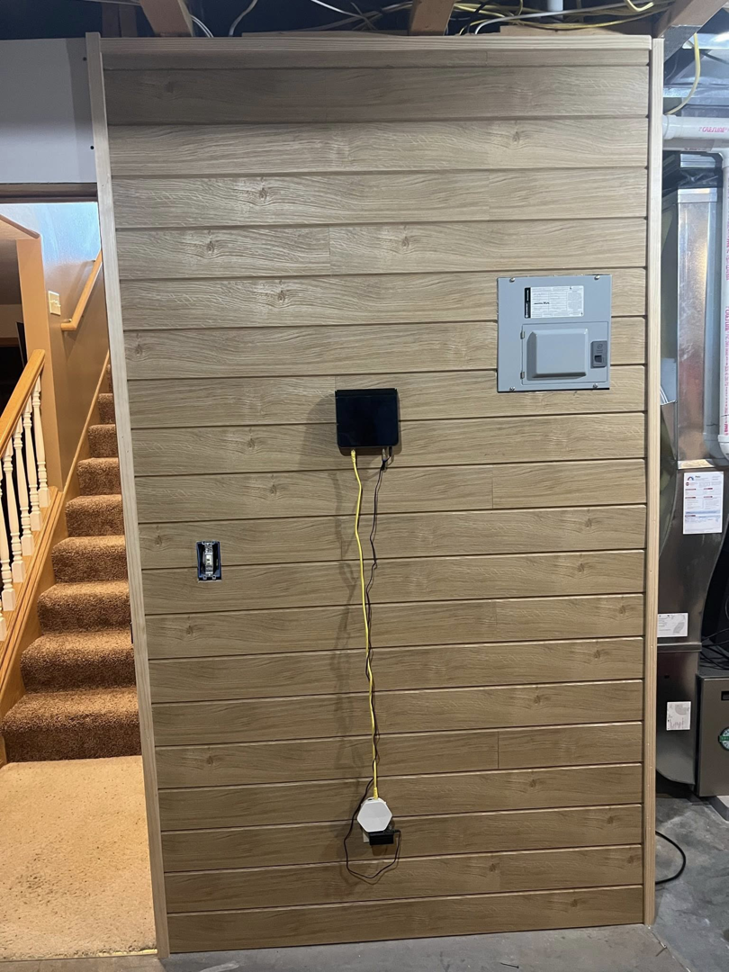 Finished utility wall with wood-look paneling and electrical outlets by Halls Home Solutions in Pierre, SD