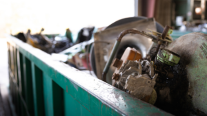 Close-up of various metal parts and junk collected in a green container by Bee Green Recycling in Richmond, VA