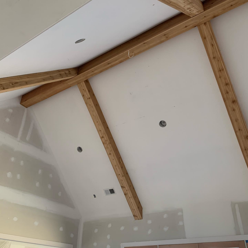Vaulted ceiling with exposed wooden beams and drywall finishing in progress by Mike Murphy Builders, LLC in Memphis, TN.