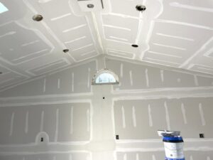 A room with newly installed drywall and a vaulted ceiling, taped and mudded by Castle Drywall & Plaster in Chesapeake, VA.
