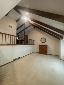 A spacious living room with vaulted ceilings and exposed beams, showcasing interior painting services by K&T PRO Painting in St. Cloud, MN.