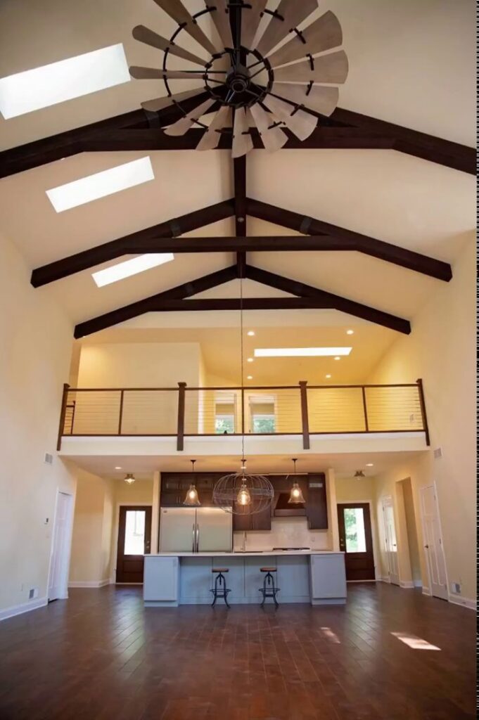 A grand living area with a vaulted ceiling, exposed beams, and a unique ceiling fan by Corrado Custom Homes, Inc. in Kutztown, PA