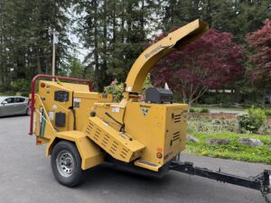 A large yellow Vermeer wood chipper used by AA Tree Service for processing tree debris in Kent, WA.