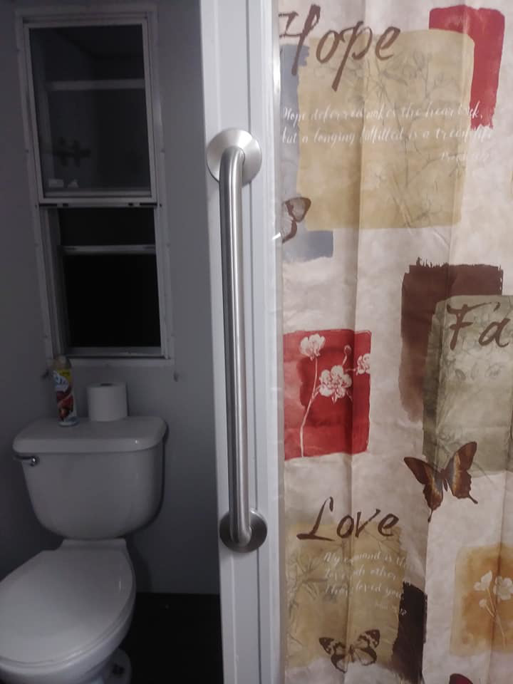 A vertical grab bar installed in a bathroom doorway or shower area by Home Solutions of Kansas City in Kansas City, MO