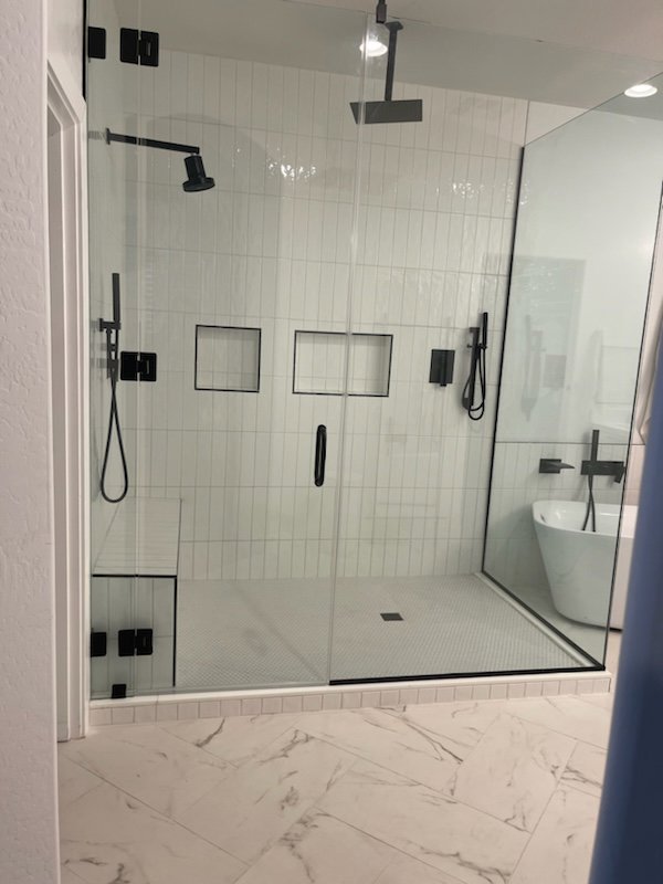 Vertical subway tile shower installation with black fixtures by Jocia Construction Services in Gilbert, AZ.