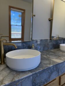 A newly installed vessel sink and gold faucet on a marble countertop by AZ New Bath in Glendale, AZ