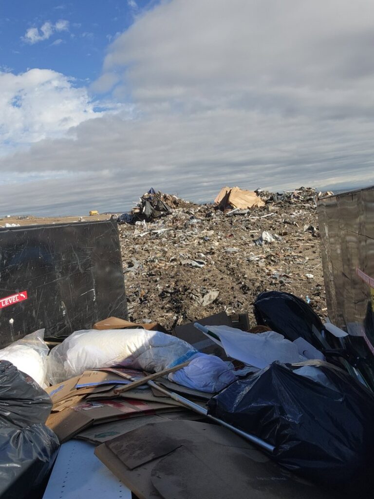 A view from inside a dumpster showing a large pile of trash at a landfill, handled by Jigsaw Transport and Waste in Albuquerque, NM.