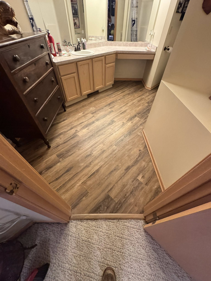 View of new laminate flooring in a bathroom from a doorway by All-In-One Contracting and Home Improvement in Canton, OH