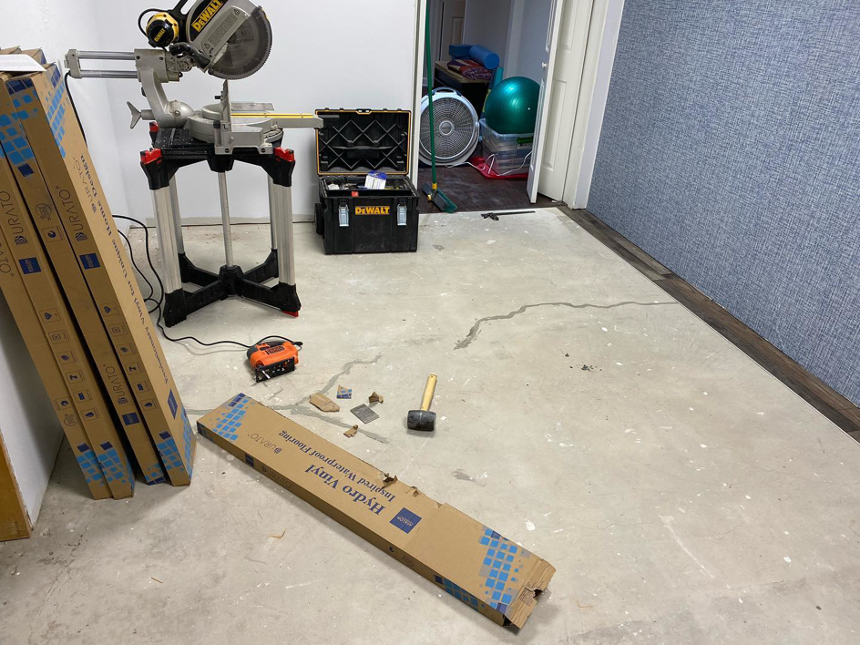 A room prepped for vinyl flooring installation with materials and tools by North Shore Construction & Renovation in Philadelphia, PA.