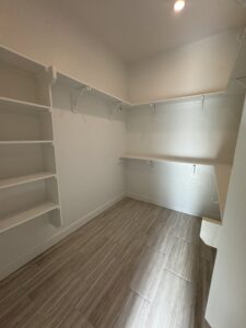 A renovated walk-in closet featuring new tile flooring and custom shelving, completed by Roaring Lion Renovations, LLC in Houston, TX.