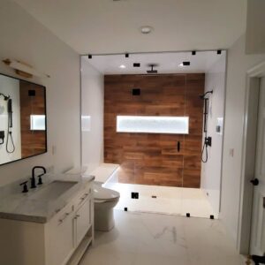 A luxurious walk-in shower with a wooden accent wall in a renovated bathroom by Mainville Construction & Remodeling LLC in Newington, CT.