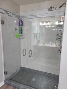 A custom walk-in shower with double glass doors and a dark textured shower pan installed by Bath Pro in Florence, KY