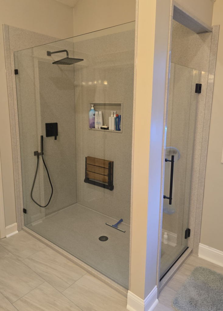 A spacious walk-in shower with a clear glass enclosure and built-in seat by The Shower Company in Kansas City, MO.