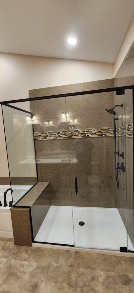 A newly installed walk-in shower with a glass enclosure and tiled walls by Willhite Construction in O'Fallon, MO.