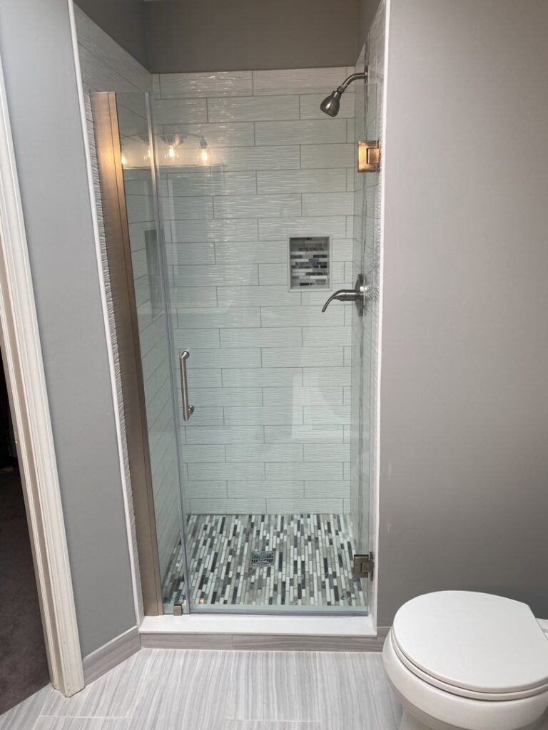 A newly installed walk-in shower with glass door and modern tile work by Grizzly Renovations in Naperville, IL