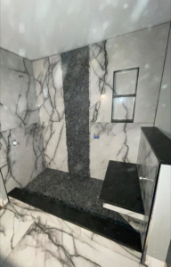 A walk-in shower featuring marble-look and dark accent tile installation by A&L Tile LLC in San Diego, CA