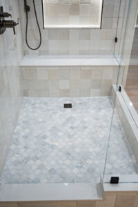 Detailed view of a walk-in shower with mosaic tile floor and subway tile walls by Ignite Construction in Tempe, AZ.