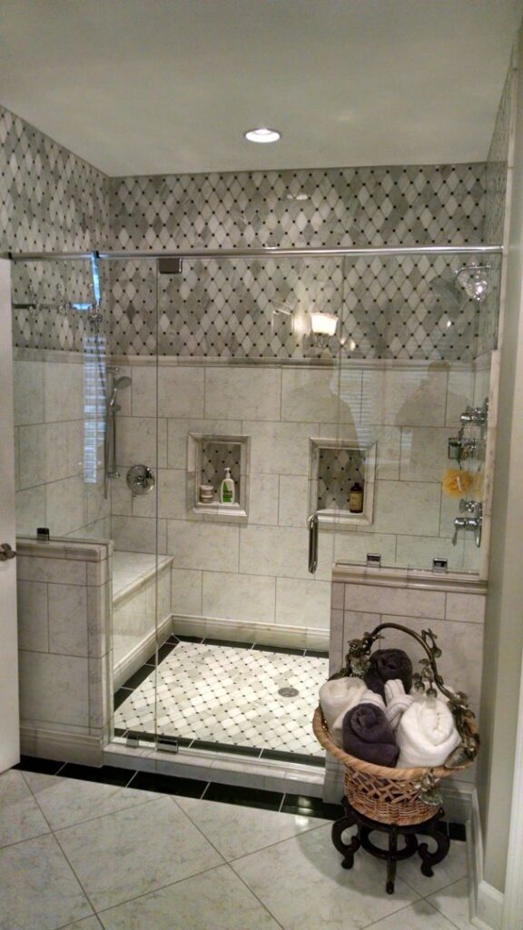 A modern walk-in shower with intricate tile work and glass enclosure by Unique Construction Services in Knoxville, TN