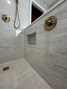 Interior view of a custom walk-in shower with tiled walls and floor by Quality Work Home Services in Syracuse, NY.