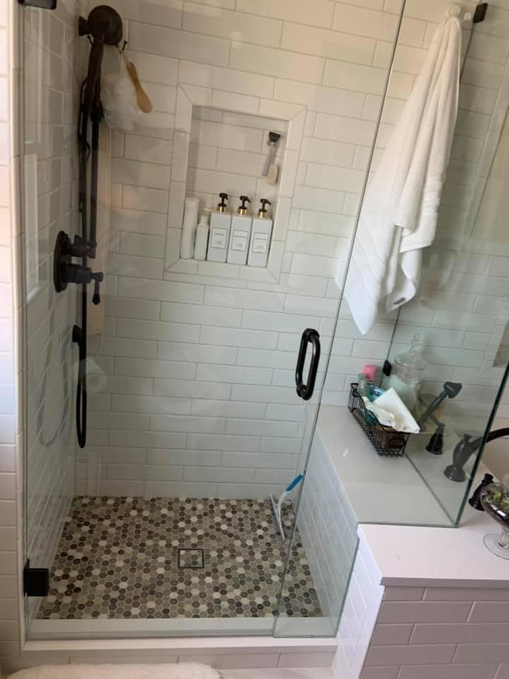 A modern walk-in shower with subway tile walls and a mosaic floor installed by Solis and Son Construction in Denver, CO.