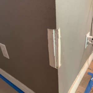 A wall corner with spackle applied over cuts, showing repair work in progress by Island Handyman in Honolulu, HI.