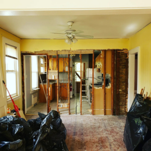 Wall demolition in a kitchen area with exposed brick and studs by CJM Builders Inc in Wilmington, MA.