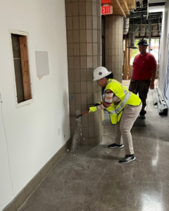 A worker in a hard hat and safety vest performing wall demolition and repair work for Ringenberg Construction, LLC in Virginia Beach, VA