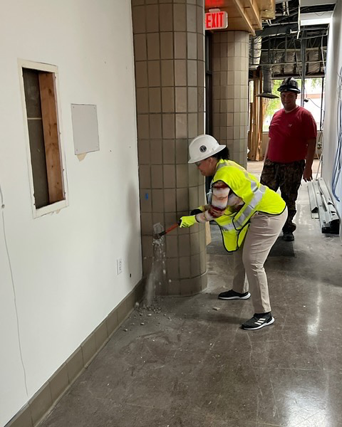 A worker in a hard hat and safety vest performing wall demolition and repair work for Ringenberg Construction, LLC in Virginia Beach, VA