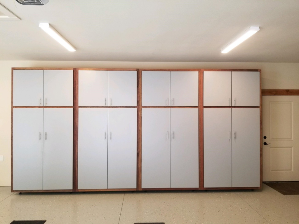 A wall of grey garage cabinets with brown trim, including tall and upper units, installed by NW Garage Cabinet Company in Ridgefield, WA.