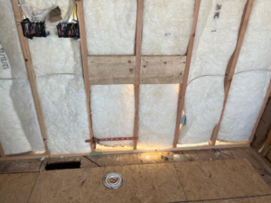 Wall insulation and electrical rough-in boxes in a room undergoing renovation by Kliesen Construction Company in Pueblo, CO.