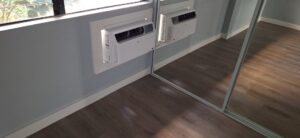 Two wall-mounted air conditioning units installed in a room with new flooring by Just-In-Time Handyman Services in Honolulu, HI.