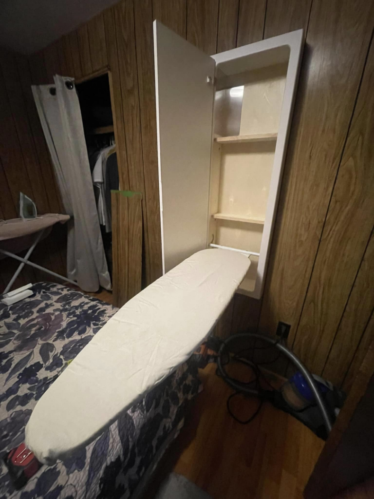 A newly installed wall-mounted ironing board cabinet by Infinity Maintenance Services, Inc. in Brattleboro, VT.