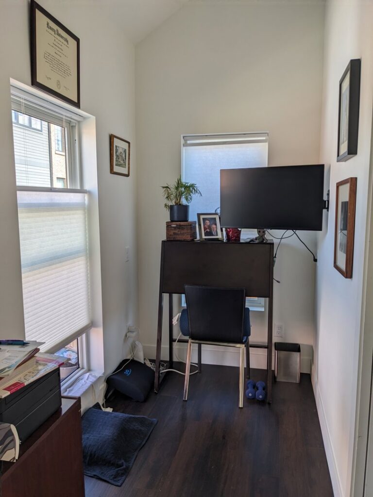 Home office with a wall-mounted monitor and window blinds, demonstrating installation services by Radiant Homes LLC in Denver, CO.