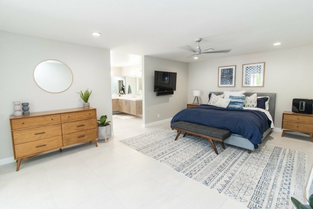 A wall-mounted television installed in a modern bedroom by Patterson Homes LLC in Scottsdale, AZ.