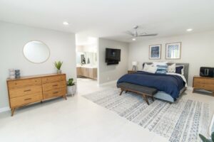 A wall-mounted television installed in a modern bedroom by Patterson Homes LLC in Scottsdale, AZ.