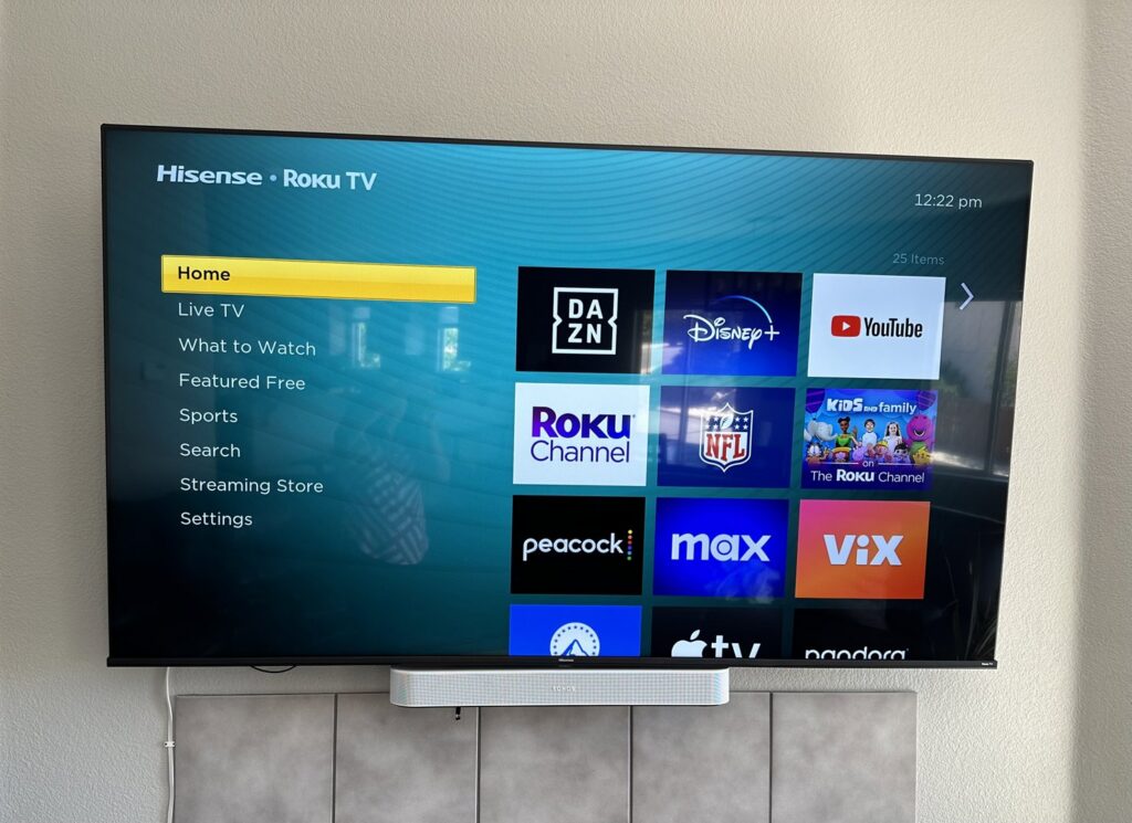 A wall-mounted Hisense Roku TV with a soundbar installed below it by Prospective 1, LLC in Sparks, NV.
