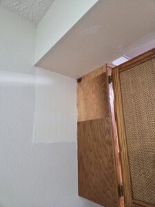 A wall patch with spackle and primer, indicating drywall repair in progress by Infinity Handyman in Anchorage, AK