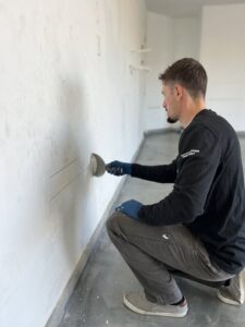 A handyman performing wall repair and drywall finishing for Peak Handyman Services in Las Vegas, NV.