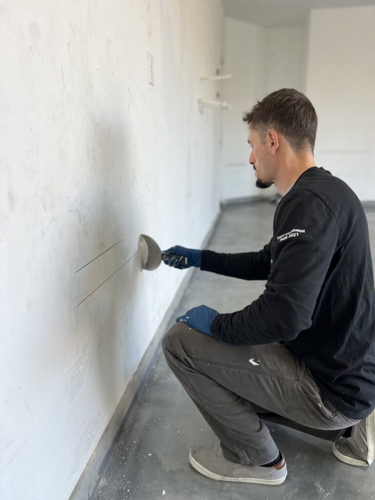 A handyman performing wall repair and drywall finishing for Peak Handyman Services in Las Vegas, NV.