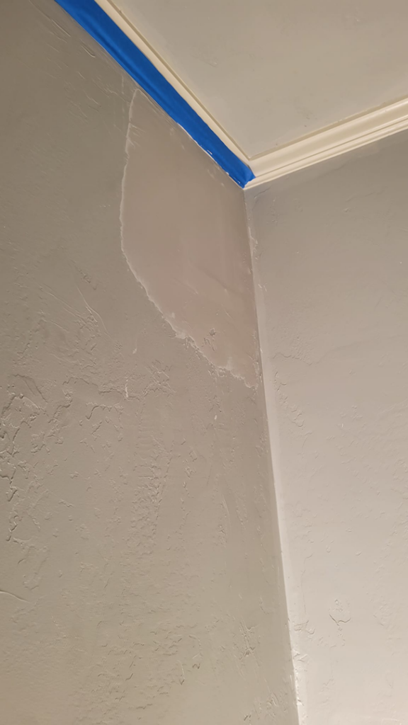 Wall repair and painting preparation with blue tape by M&M Drywall and Construction in Enid, OK