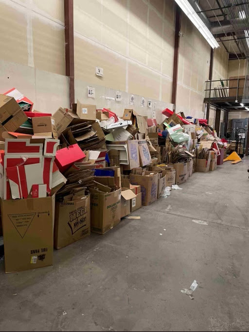 A large pile of cardboard boxes and debris inside a warehouse, ready for commercial junk removal by Gone Junkin' Vegas in Henderson, NV.