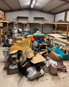 A massive pile of assorted junk and debris inside a warehouse, awaiting removal by G.I. HAUL Austin, TX.