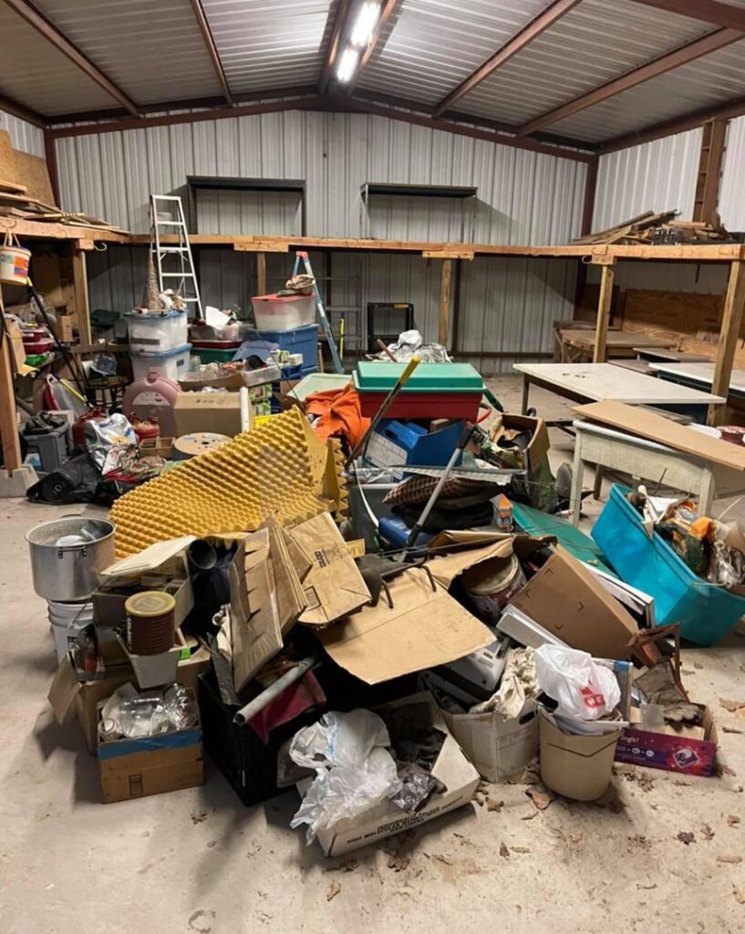 A massive pile of assorted junk and debris inside a warehouse, awaiting removal by G.I. HAUL Austin, TX.