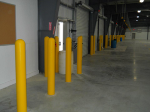 Warehouse safety bollards installation leading to an exit by Woodsmith Fence Corp in Lockport, NY.