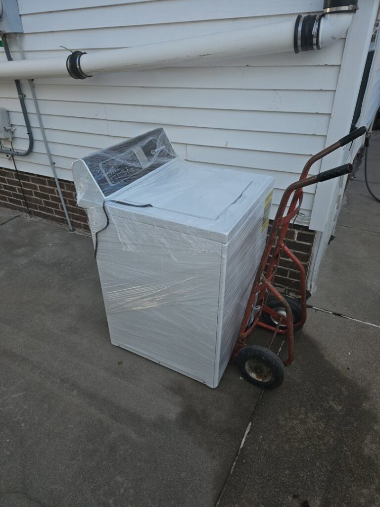 A washing machine wrapped in plastic, ready for appliance pickup by TrashnSell in Grand Island, NE