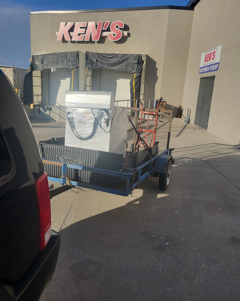 A washing machine and other items on a trailer for junk removal by TrashnSell in Grand Island, NE